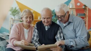 Tres personas mayores revisan un álbum familiar, reflejo del proceso de reagrupación familiar en España que gestiona DEI Abogacía