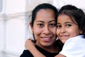 Madre e hija inmigrantes abrazadas, casos que DEI Abogacía gestiona tras las modificaciones del nuevo reglamento de extranjería