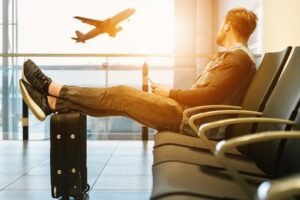 Hombre en sala de espera del aeropuerto valorando entre residencia no lucrativa o visado nómada digital con DEI Abogacía